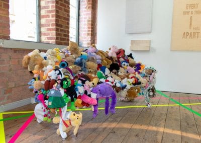 A soft sculpture by Stuart Semple, park bench covered with soft toys